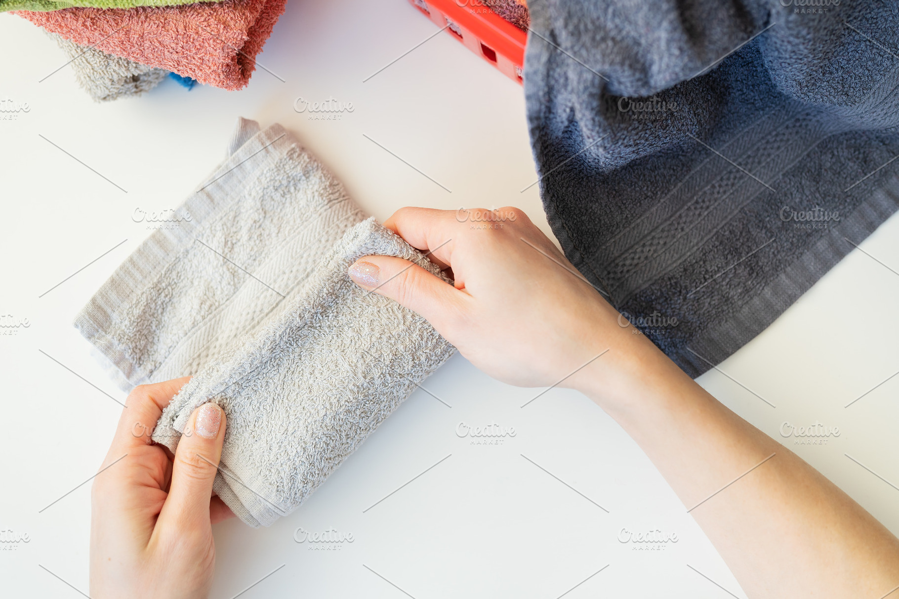 A woman's hand holds a terry towel from a clothes basket. Towel after washing., a Beauty & Fashion Photo by Artsaba Family