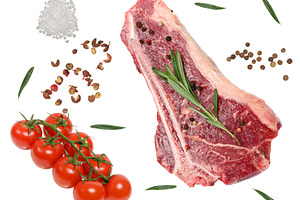 A raw bone-in steak with pepper and rosemary, a vine of ripe che, a Food & Drink Photo by ndanko
