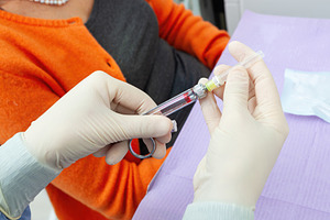 Doctor preparing syringe for injection to mature adult patient, a Health & Medical Photo by Antonio Gravante Market