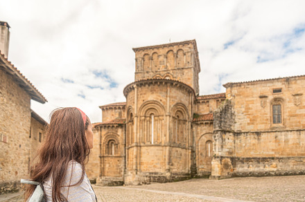 Anonymous woman visiting ancient stone catholic church, a Holiday Photo by Iván Moreno STOCK PHOTO