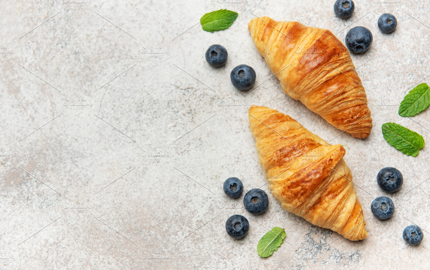 Delicious french croissants with fresh blueberries and mint on a, a Food & Drink Photo by Olena Rudo