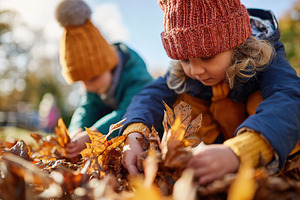 Children joyfully collecting colorful autumn leaves in a park during a bright f, a Person Photo by AlyaAnd