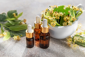 Linden essential oil dropping bottles and flowers, a Health & Medical Photo by Olena Rudo