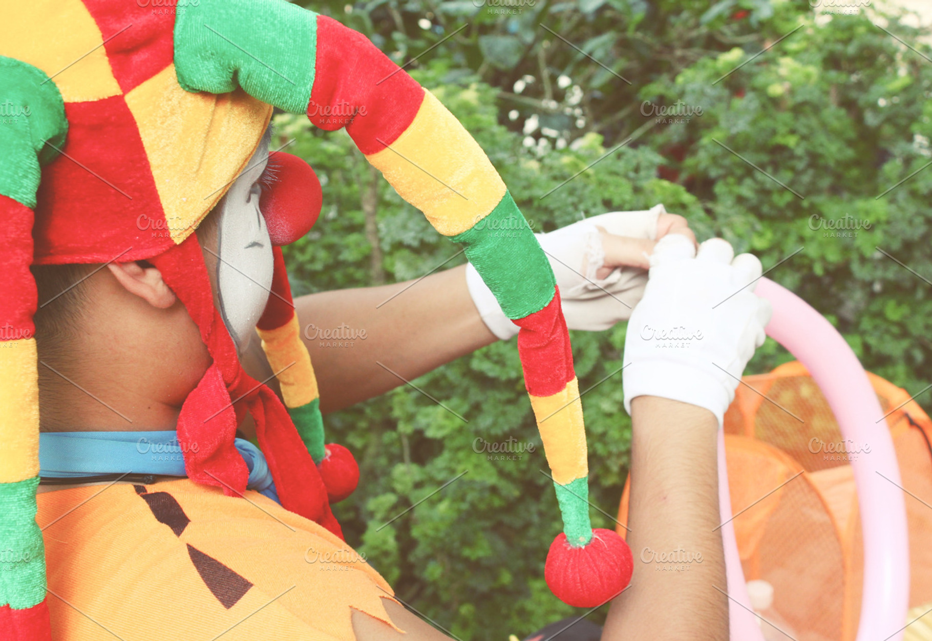 A joker is twisting a balloon