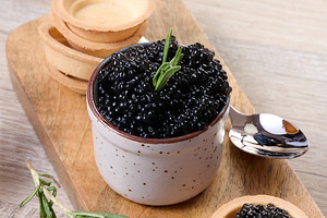 Close-up of black caviar in ceramic pot and mini tartlet placed, a Food & Drink Photo by ndanko