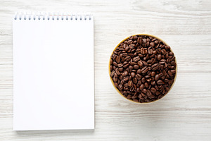 Organic Roasted Coffee Beans in a Bowl, Blank Notepad, top view., a Food & Drink Photo by LiudmylaChuhunova