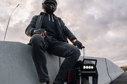 A male rider in protective gear riding an electric wheel. Urban