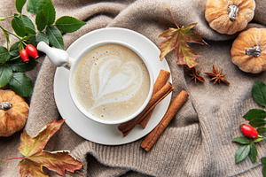 Warm autumn coffee with heart latte art and spices