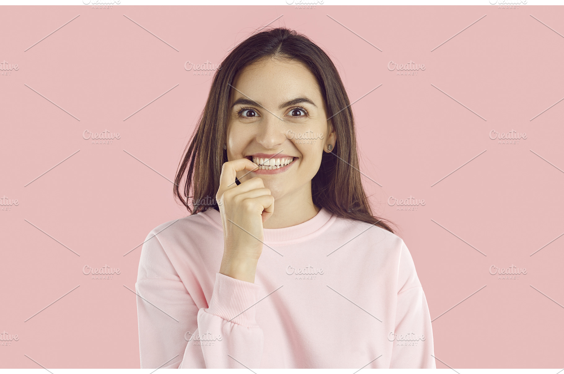 Excited young woman biting finger as, a Person Photo by StudioRomantic