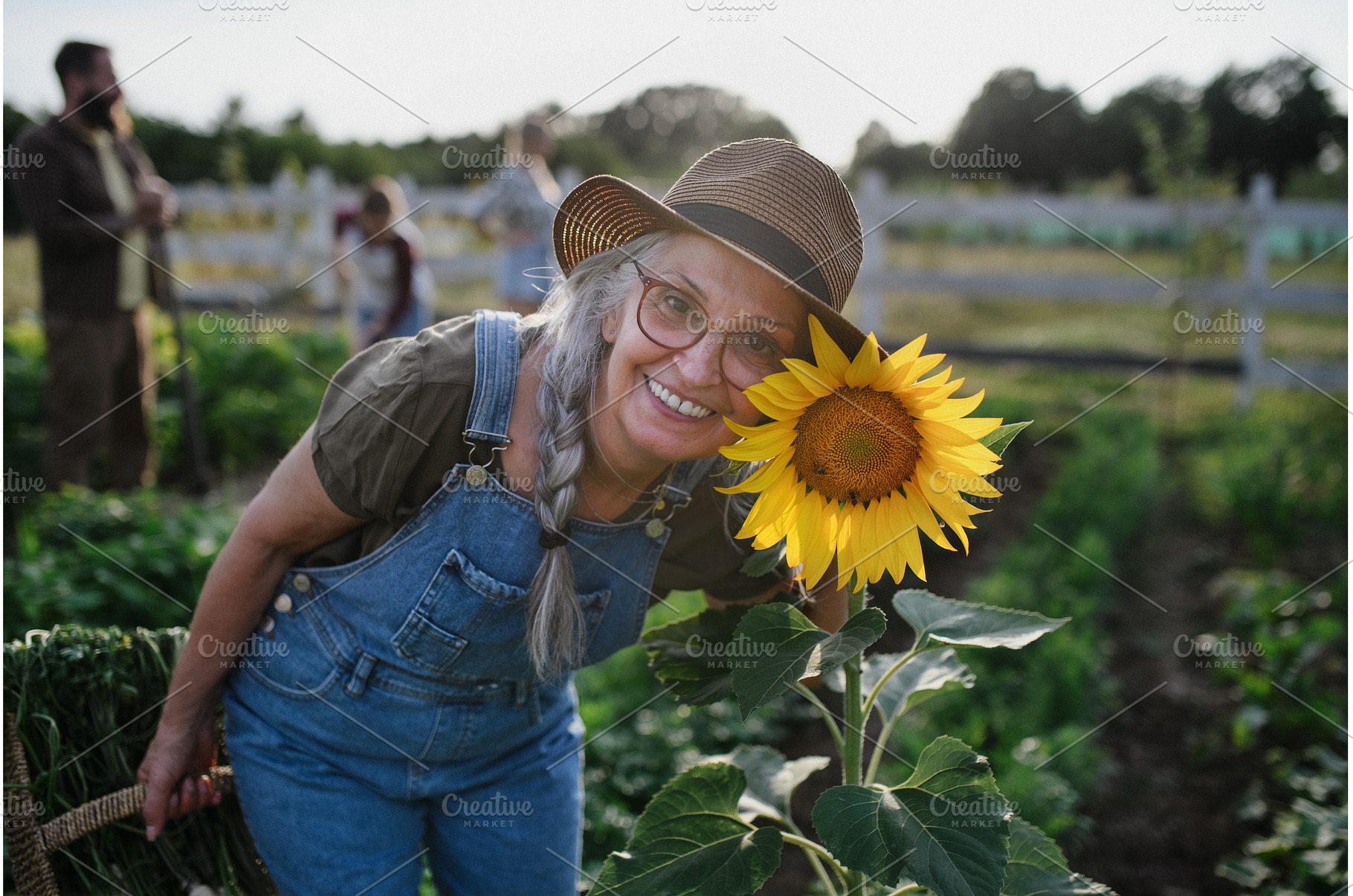 Senior female farmer with sunflower, a Person Photo by HalfPoint
