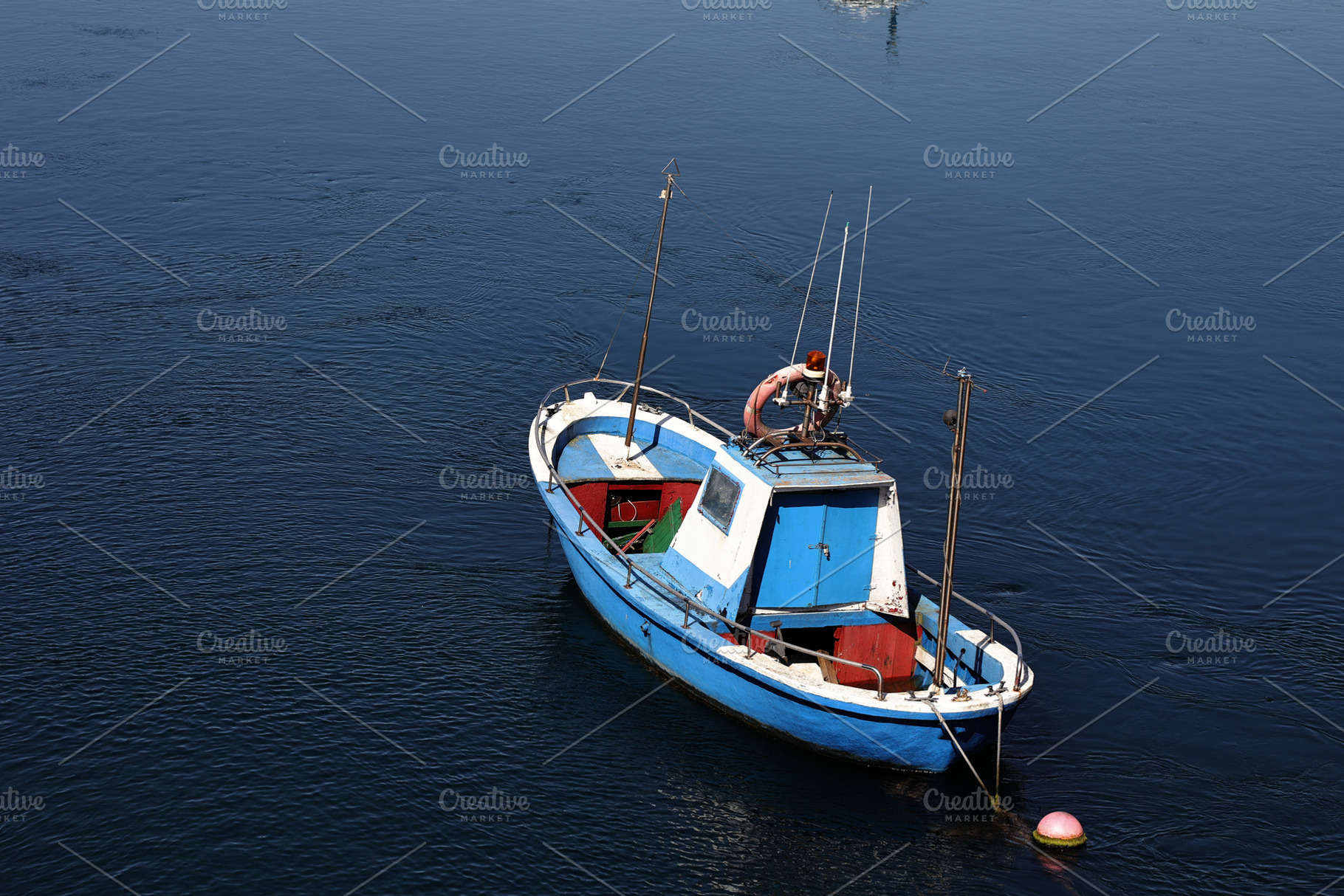 Blue fishing boat anchored in calm w, a Transportation Photo by Perpis