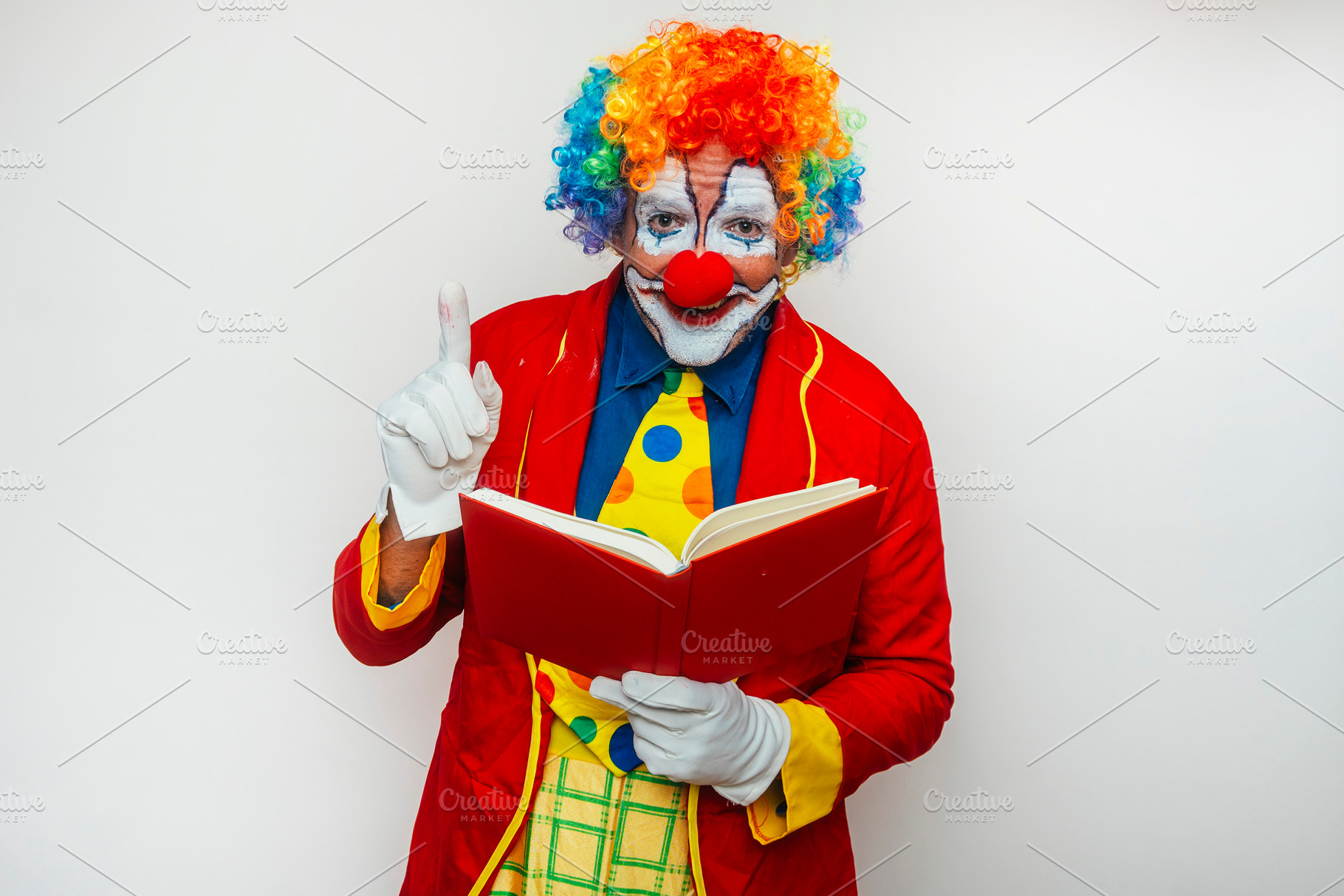 Happy smiling clown reading a book, a Person Photo by karrastock
