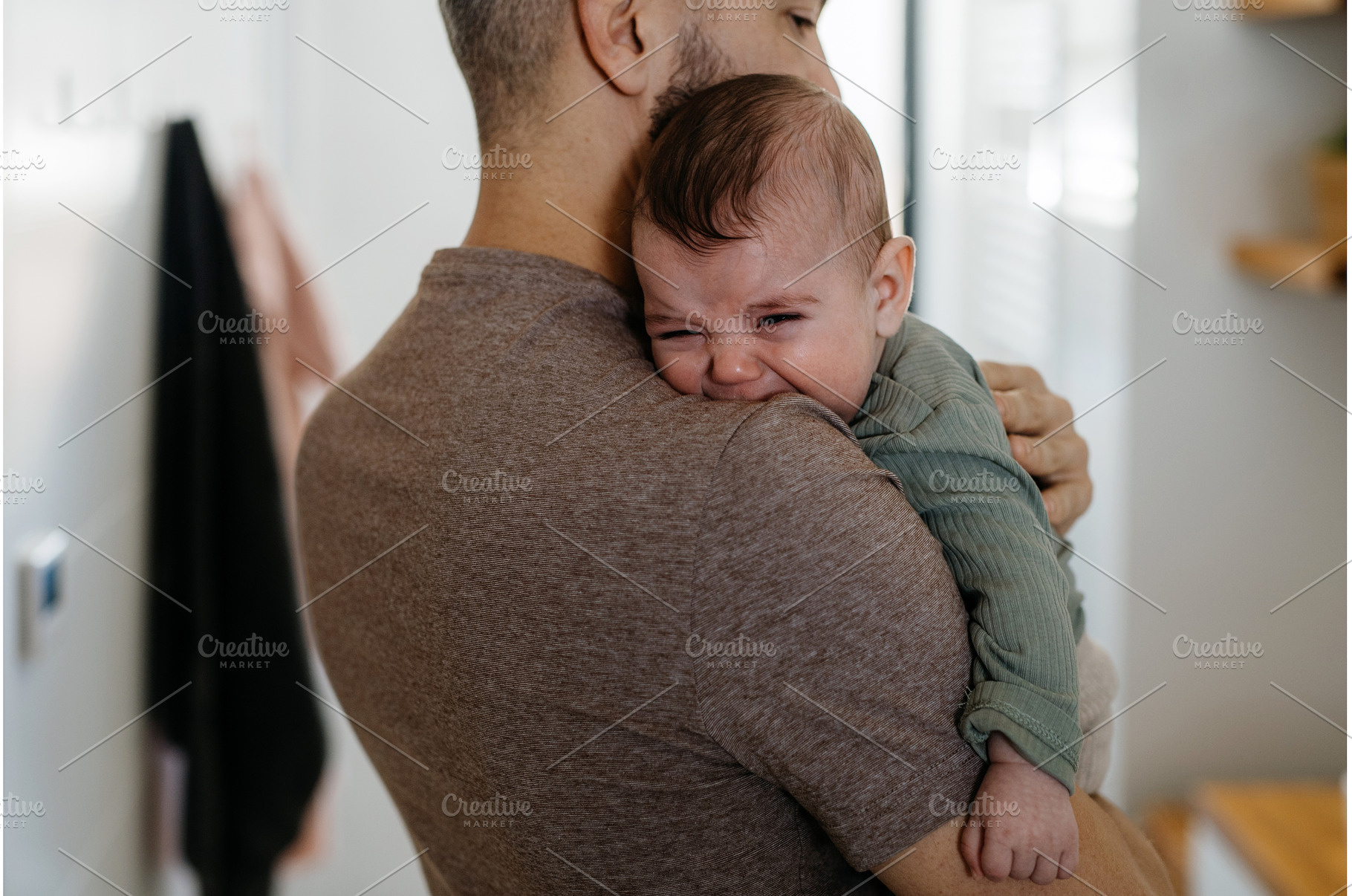 Father comforting his crying baby, a Person Photo by HalfPoint