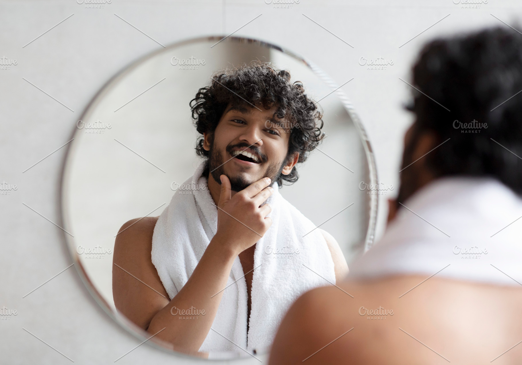 Male facial skincare concept. Young indian man touching beard, caring for skin, a Person Photo by Prostock-Studio