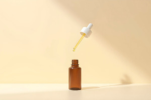 Glass Dropper Bottle on Beige Backgr, a Photo by LOGOCREATIVE