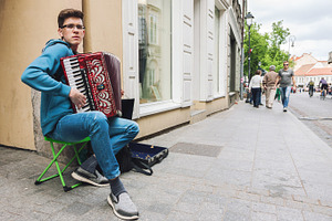 Young man playing accordion, a Person Photo by BOOCYS