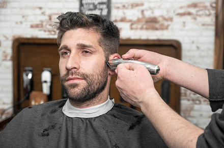 Man barber cutting hair of male client with clipper at barber shop. Hairstyling, a Person Photo by david.herraez.calzad