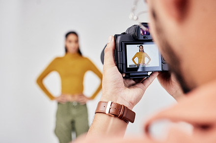 Camera, photography and photographer with woman fashion model in studio for creative, advertising and image. Media, backstage and professional man with girl and equipment for photoshoot capture, a Photo by Peopleimages.com