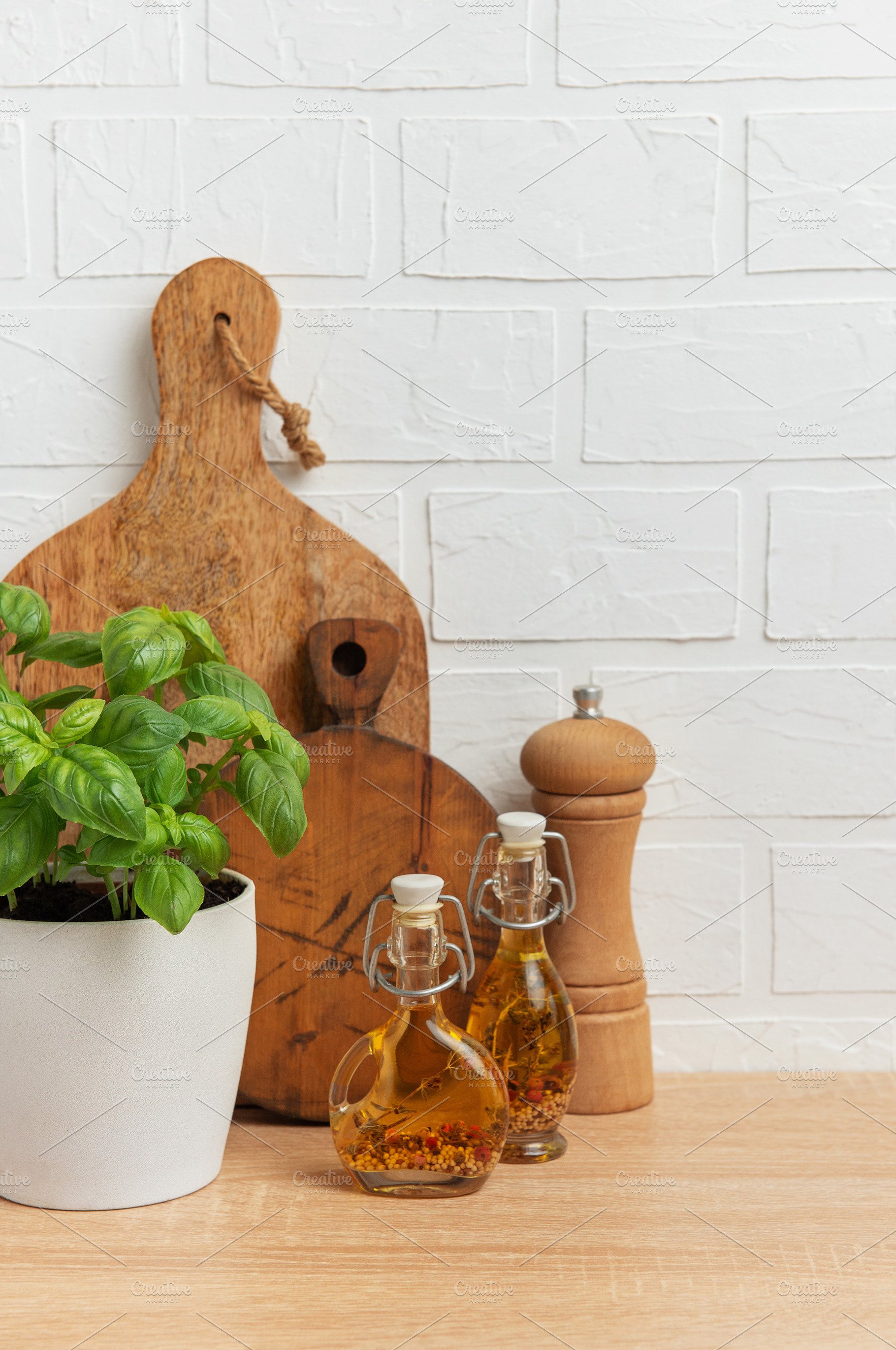 Fresh basil, olive oil, pepper mill and cutting boards resting o, a Food & Drink Photo by Olena Rudo