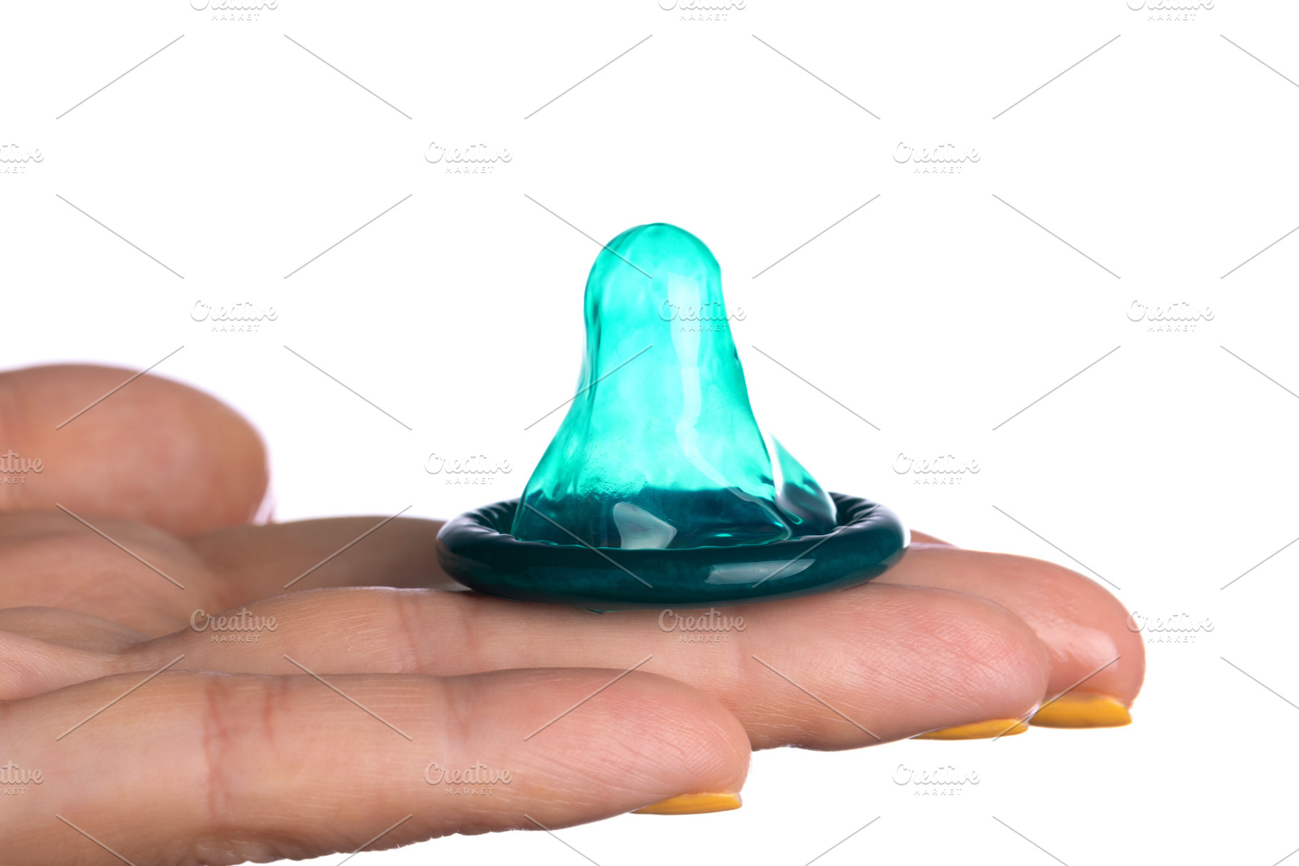 Close-up of a lubricated green condom resting on fingers with ye, a Health & Medical Photo by Ales Munt