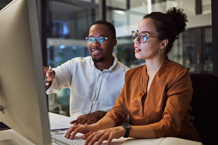 Night training, teamwork and employees planning marketing strategy in a dark office on computer at work. Corporate African man and woman talking about business collaboration during overtime together, a Photo by Peopleimages.com