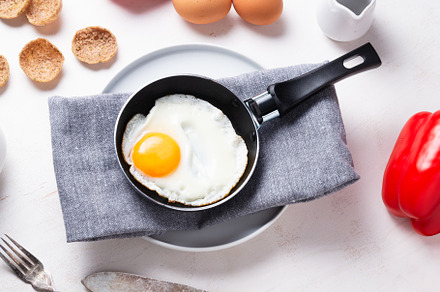 Scrambled, frying  eggs from one egg in a small pan on kitchen t, a Food & Drink Photo by MDBildes
