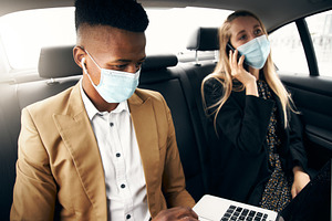 Business Couple Wearing Masks Using