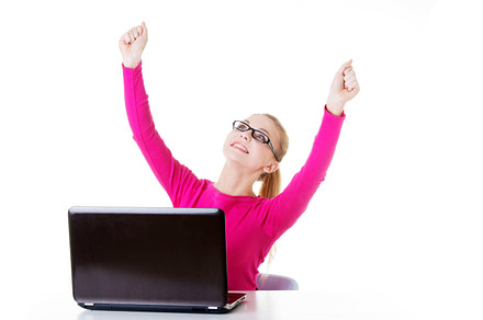 Young happy woman sitting in front of laptop containing laptop, woman, and