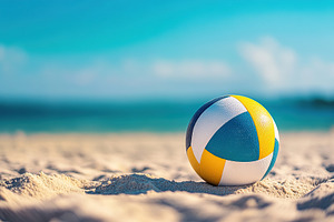 Clean volleyball on sandy beach with ocean view under clear sky, a Photo by AlyaAnd