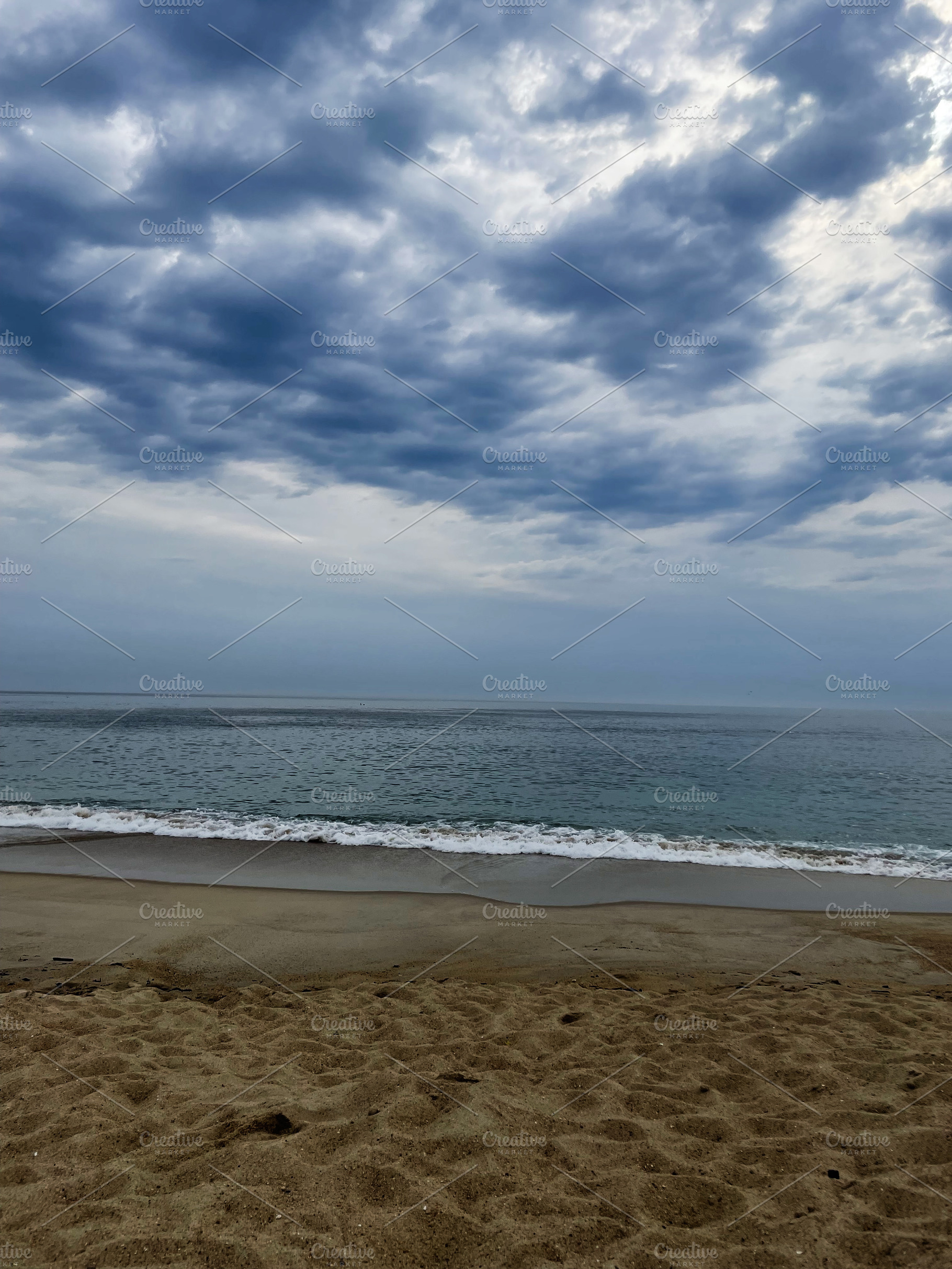 Sunlit clouded sky over peaceful beach during quiet morning, a Photo by AS photostudio
