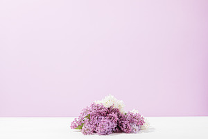 Bunch of fresh lilac flowers lies on white table