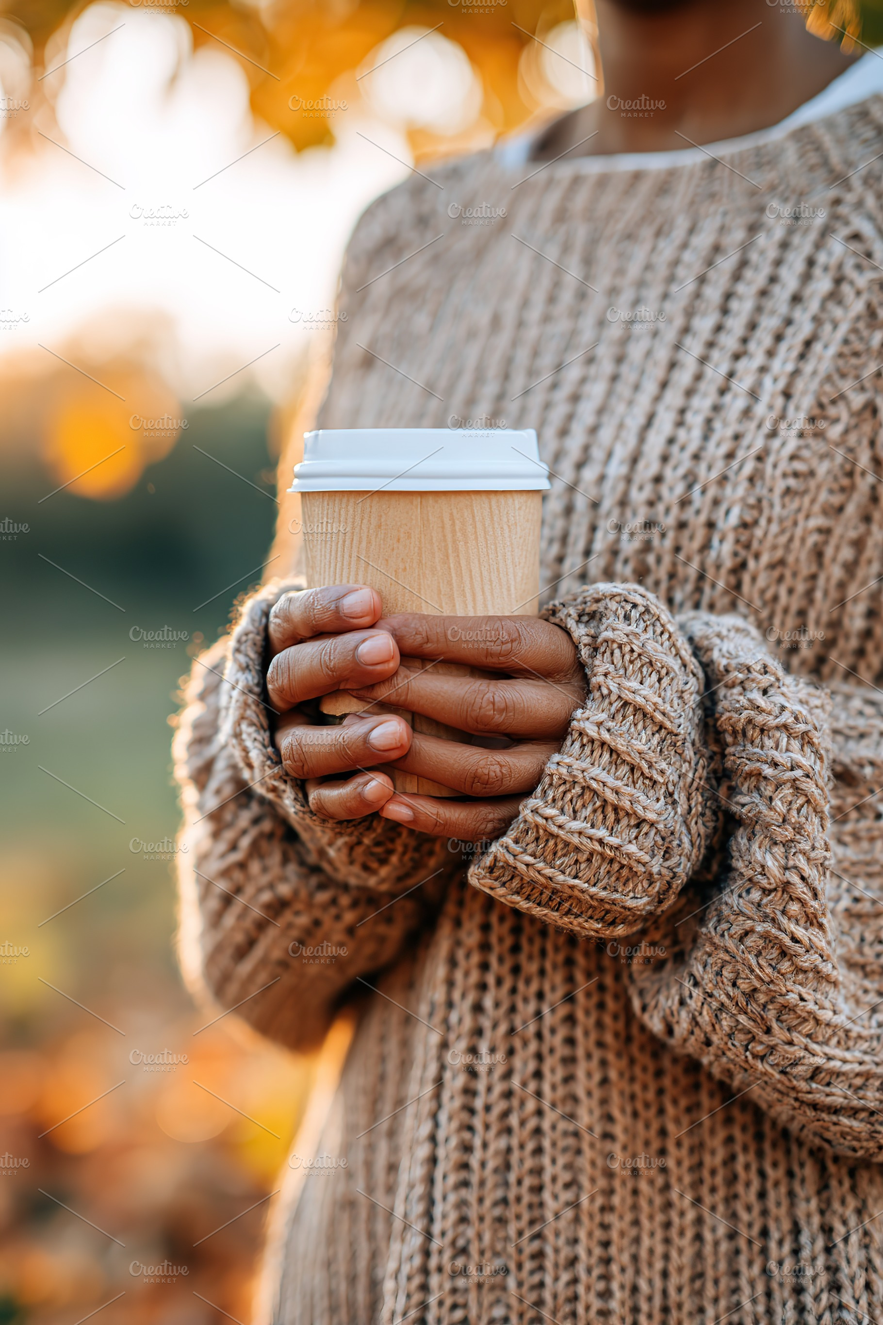 Enjoying a warm beverage in an oversized knit sweater during autumn sunset, a Photo by AlyaAnd