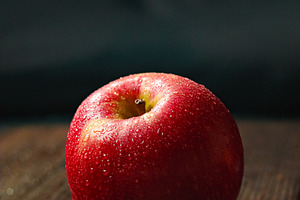 Healthy red apple with fresh water drops on rustic wooden board, representing o, a Photo by Studio ANNA