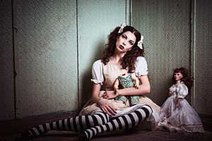 Strange sad girl with dolls