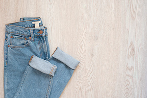 Blue jeans on a wooden background. F