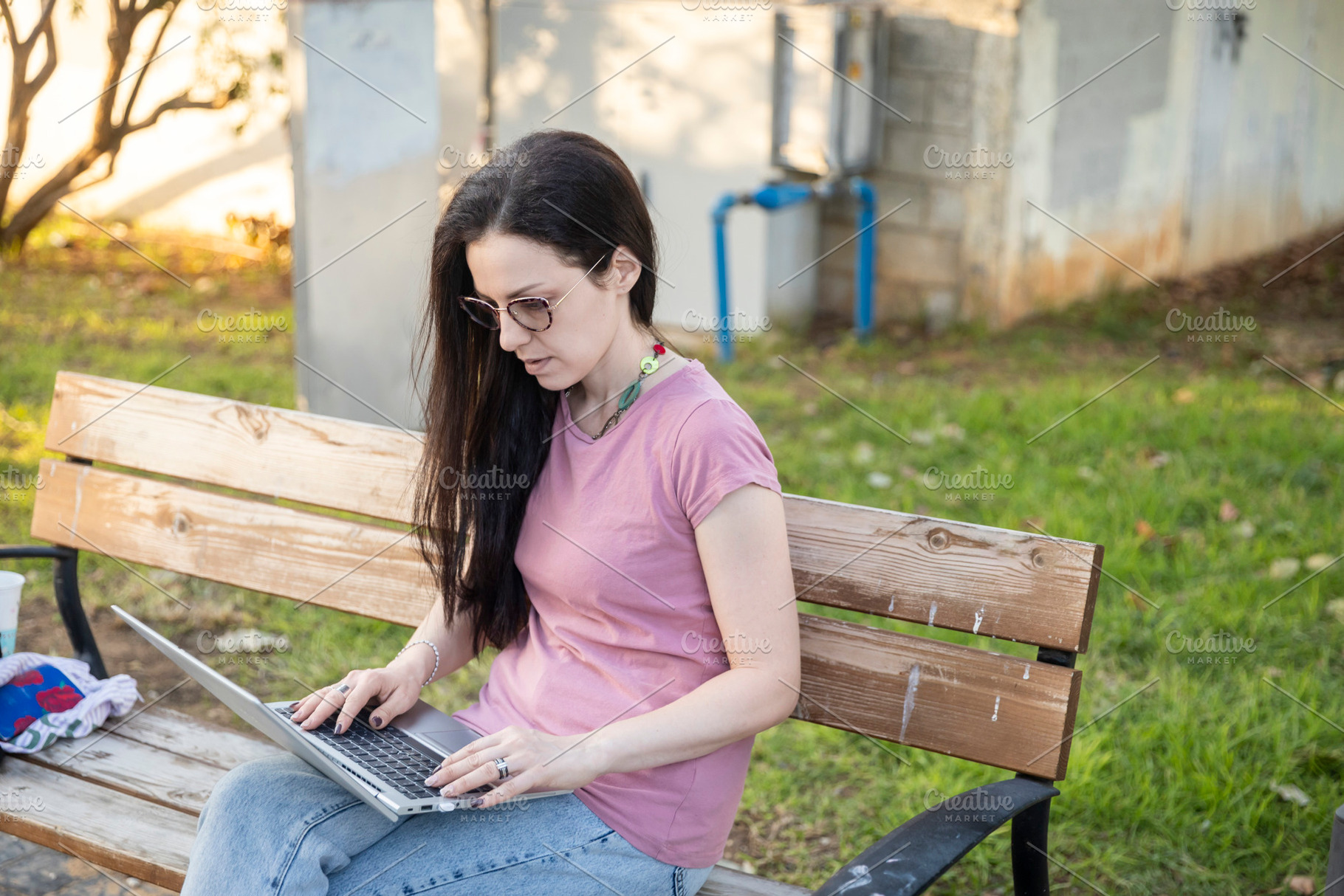 Woman in casual wear and glasses sitting on a park bench, workin, a Person Photo by Imaginarium