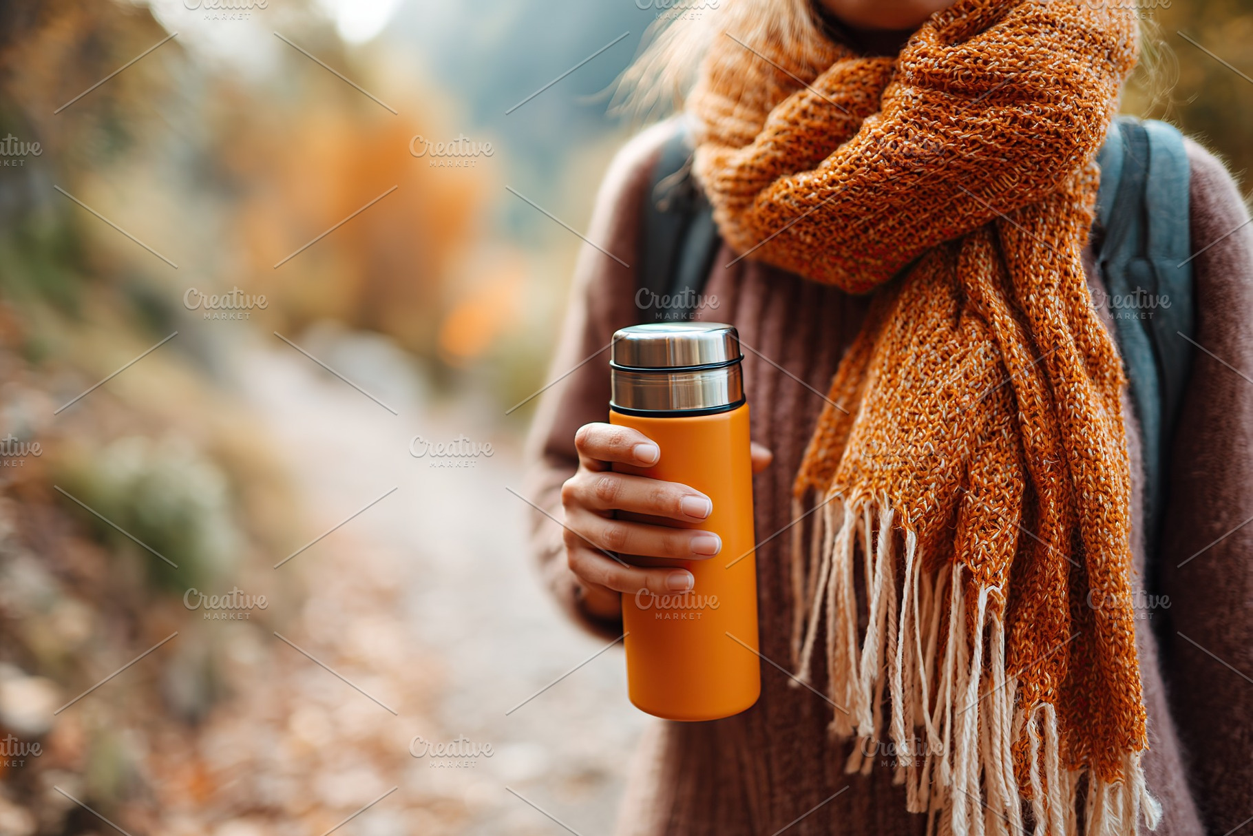 Walking along the forest trail while holding a thermos in autumn foliage, a Person Photo by AlyaAnd
