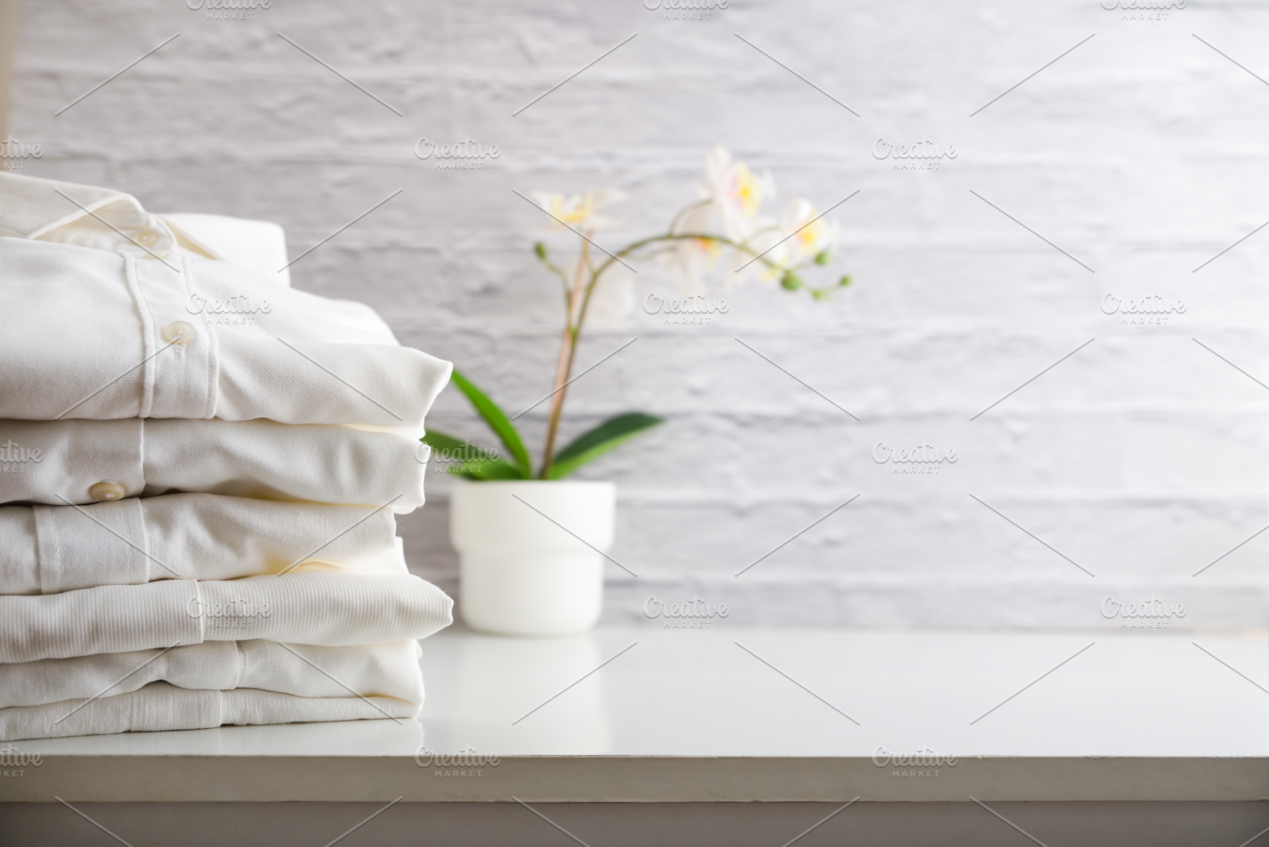 Stack of clean white shirts on a wooden cabinet, a Sports & Recreation Photo by Davizro's Market