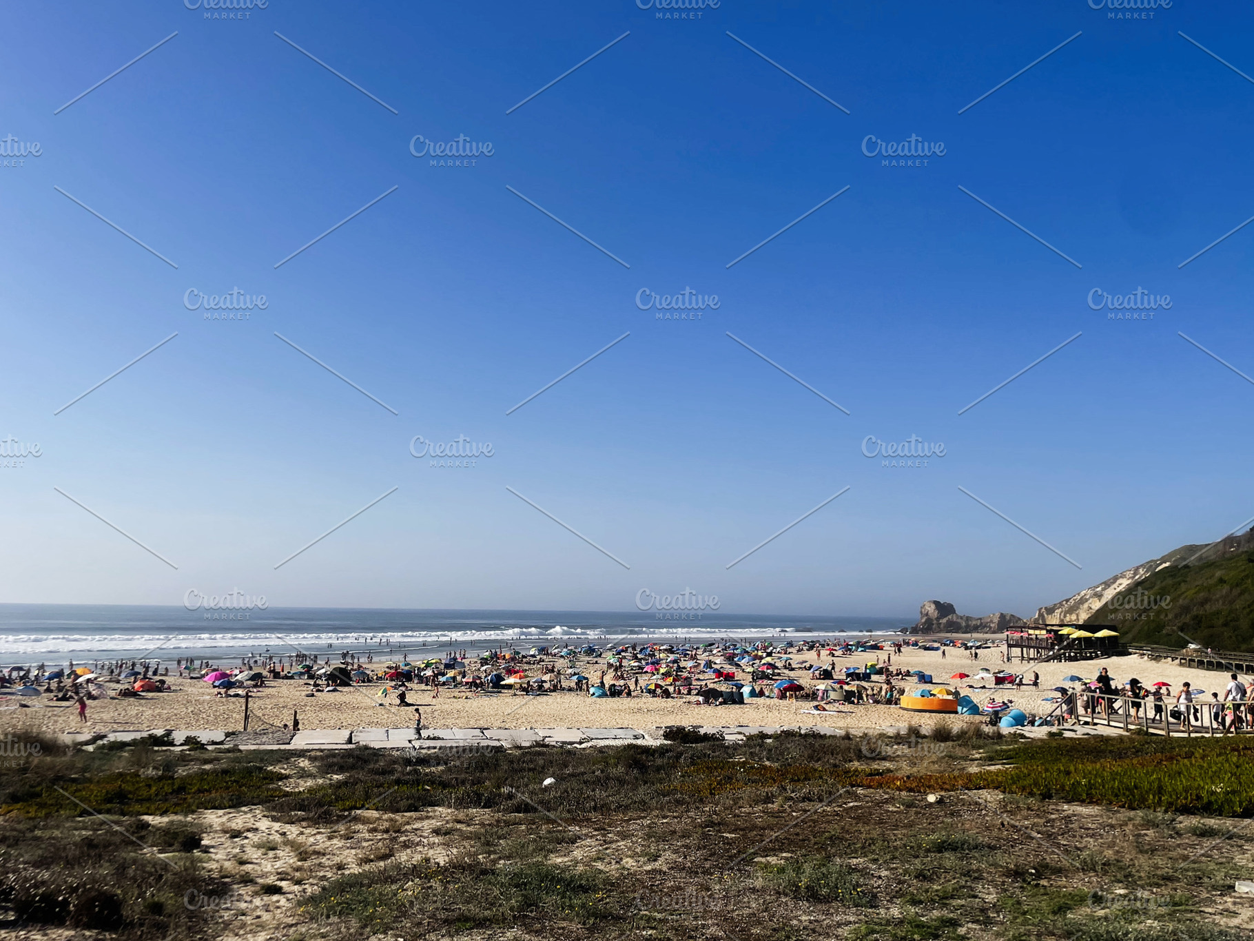 Crowded beach on a sunny day at Praia das Azenhas, Portugal coastline, a Photo by AS photostudio