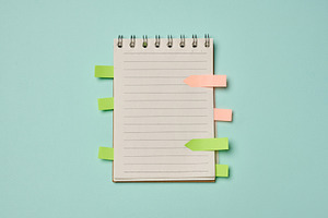Spiral-bound lined notebook with colorful sticky index tabs on a, a Business Photo by ndanko