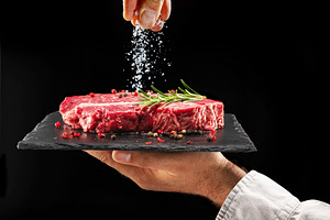 Chef is salting raw steak, a Food & Drink Photo by Volff