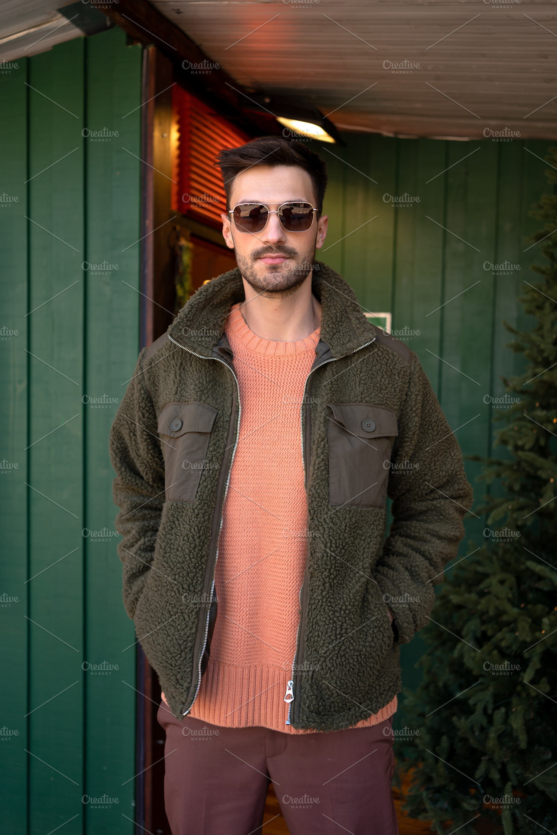 Confident handsome man standing with hands in pockets outside house, a Person Photo by andreonegin market