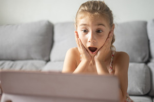 Surprised Girl Reacting to Tablet Screen at Home, a Person Photo by etorres69