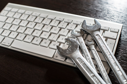 Spanners and white keyboard containing computer, support, and keyboard
