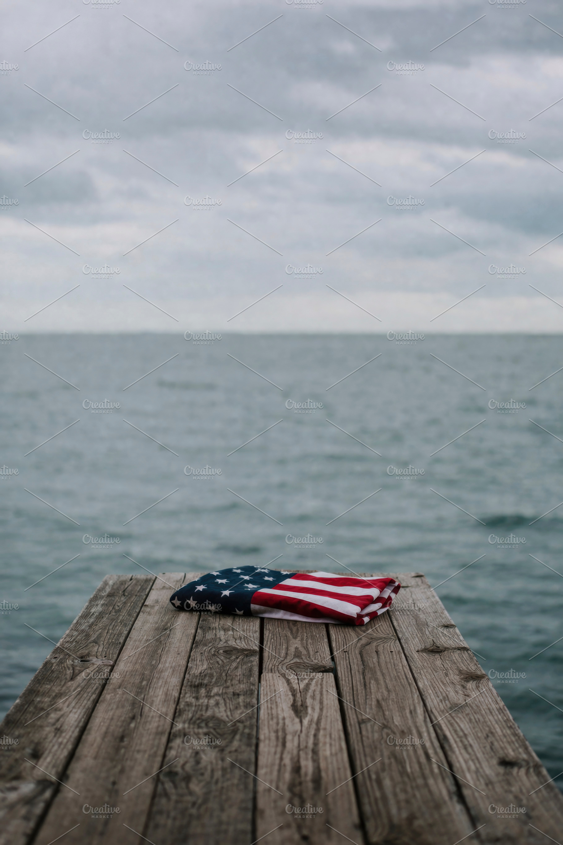 a folded US flag near the pier edge, generative AI, a Photo by Nito