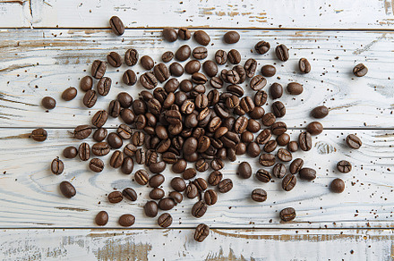 Heap of coffee beans on wooden table, a Food & Drink Photo by AlyaAnd