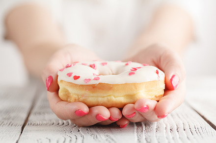Woman holding donut, a Background Photo by Andrey Stock Photos