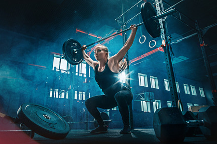 Fit young woman lifting barbells working out in a gym featuring fit, gym, and, a Sports & Recreation Photo by Volodymyr Melnyk
