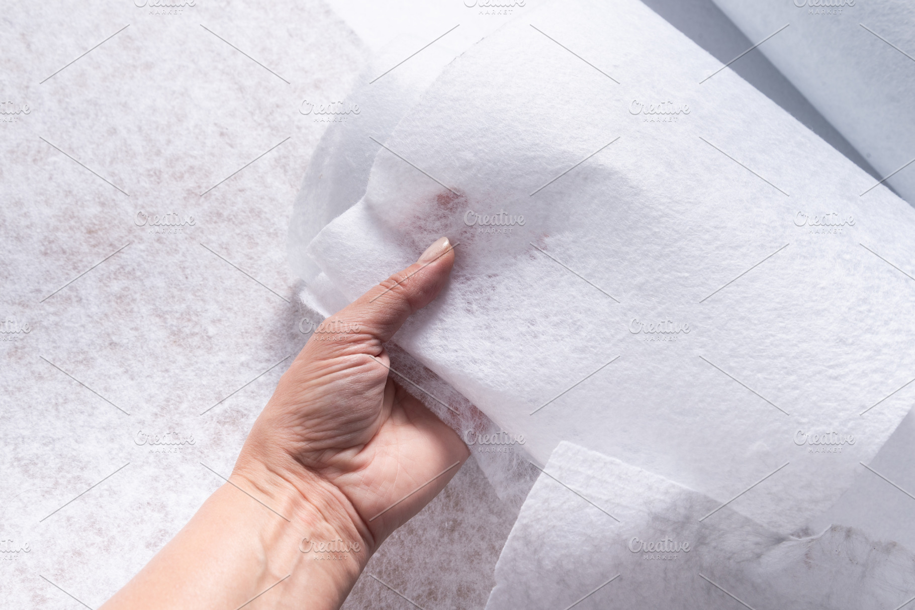 Hand Holding White Geotextile Fabric Sheet with Visible Texture,, an Industrial Photo by MDBildes