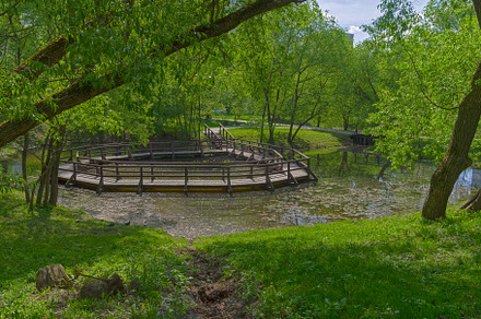 A small pond with an unusual footbridge. Moscow, Russia.